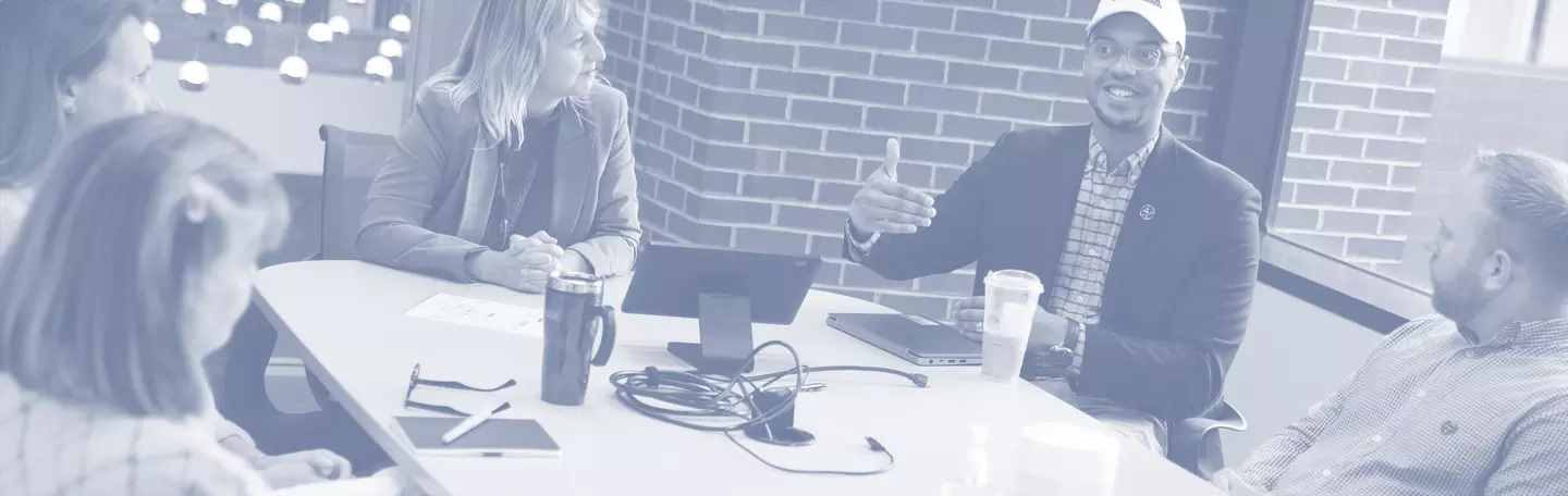 UA staff talking at a conference table